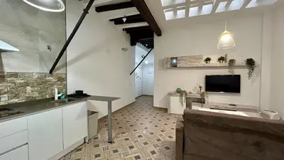 a kitchen with a table and a tv in a room at Estudio de Mia in Cádiz