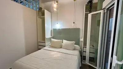 a small room with a bed and a mirror at Estudio de Mia in Cádiz