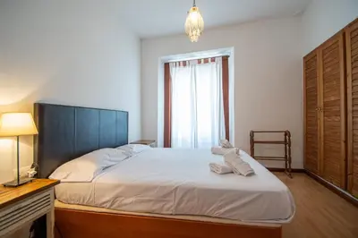 a bedroom with a bed with white sheets and a window at Apartamento Santa M Serenity Cadiz in Cádiz