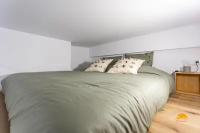 a bedroom with a large green bed with pillows at Brisa de Verano by Cadiz Time in Cádiz