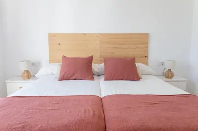 a bedroom with a large bed with two red pillows at GINVA - Apartamento en pleno centro 3 in El Puerto de Santa María
