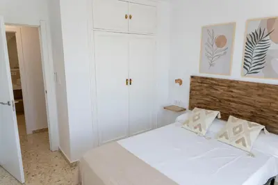a bedroom with a white bed and white cabinets at GINVA - Apartamento en pleno centro 3 in El Puerto de Santa María
