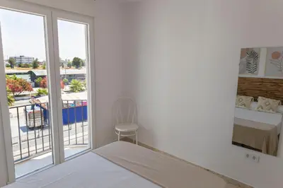 a bedroom with a bed and a view of a balcony at GINVA - Apartamento en pleno centro 3 in El Puerto de Santa María