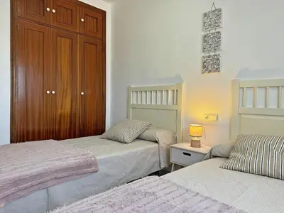 a bedroom with two beds and a wooden cabinet at Apartamento Minotauro - Ole Solutions in Jerez de la Frontera