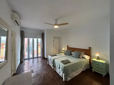 a bedroom with a bed and a large window at Quilla Puerto Sherry in El Puerto de Santa María