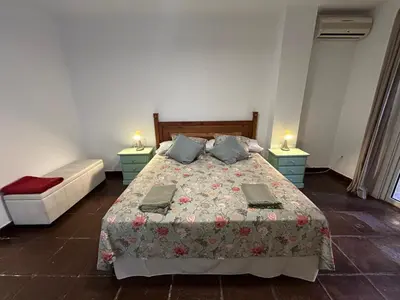 a bedroom with a bed with two tables and two lamps at Quilla Puerto Sherry in El Puerto de Santa María