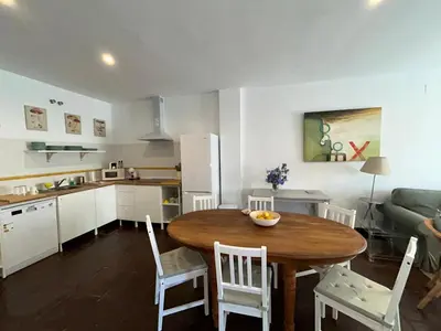 a kitchen with a wooden table and chairs in a room at Quilla Puerto Sherry in El Puerto de Santa María