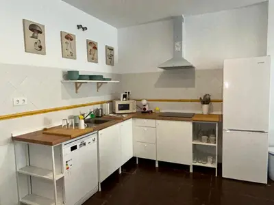 a kitchen with white cabinets and a white refrigerator at Quilla Puerto Sherry in El Puerto de Santa María