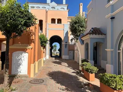 an alley in a town with an archway at Quilla Puerto Sherry in El Puerto de Santa María