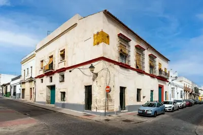 a building on the side of a street with parked cars at Casa del Reloj - Puerto De Sta María in El Puerto de Santa María