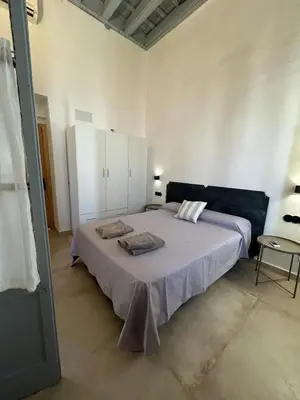 a bedroom with a large bed and white cabinets at Casa del Reloj - Puerto De Sta María in El Puerto de Santa María