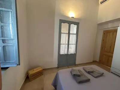 a room with a bed and a window and a door at Casa del Reloj - Puerto De Sta María in El Puerto de Santa María