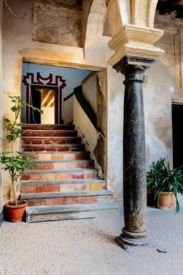 a set of stairs in a building with a column at Casa del Reloj - Puerto De Sta María in El Puerto de Santa María
