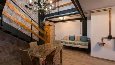 a dining room with a table and a couch at Loft Duplex La Industrial Playa in Cádiz