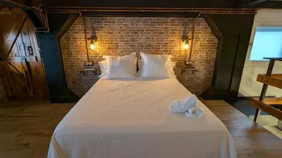 a large bed with white sheets and towels on it at Loft Duplex La Industrial Playa in Cádiz