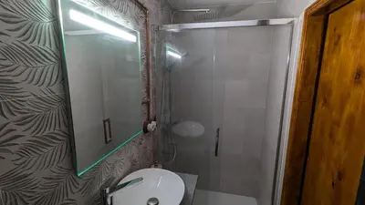 a bathroom with a toilet and a shower with a mirror at Loft Duplex La Industrial Playa in Cádiz