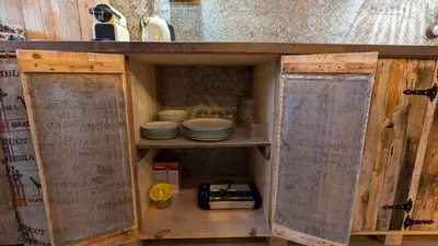 a kitchen cabinet with plates and dishes in it at Loft Duplex La Industrial Playa in Cádiz