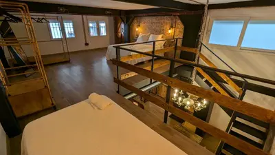 a large room with a bed and a staircase at Loft Duplex La Industrial Playa in Cádiz