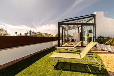 a glass house with a bench on the grass at Penthouse City Center - Jerez in Jerez de la Frontera