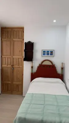 a bedroom with a bed and two wooden doors at piso de 2 dormitorios in El Puerto de Santa María