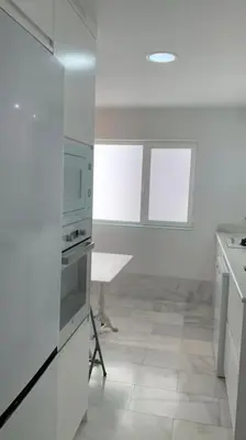 a kitchen with white appliances and a tile floor at piso de 2 dormitorios in El Puerto de Santa María