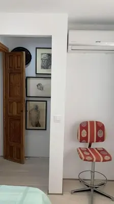a bedroom with a red chair and a door at piso de 2 dormitorios in El Puerto de Santa María