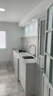 a white kitchen with a sink and a window at piso de 2 dormitorios in El Puerto de Santa María