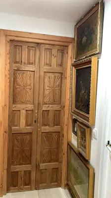 a wooden door in a room with paintings on the wall at piso de 2 dormitorios in El Puerto de Santa María