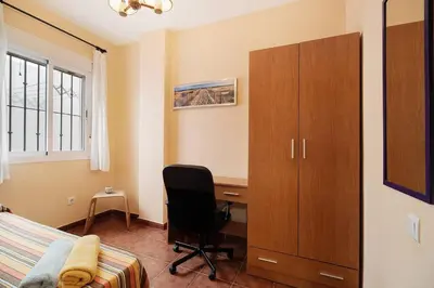 a bedroom with a desk and a bed and a chair at Apartamento Al Ándalus 43 in Chiclana de la Frontera