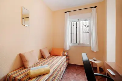 a small room with a bed and a window at Apartamento Al Ándalus 43 in Chiclana de la Frontera