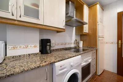 a kitchen with a washing machine and a sink at Apartamento Al Ándalus 43 in Chiclana de la Frontera
