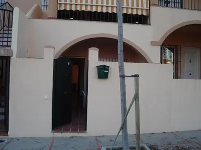 a building with a black door on the side of it at Apartamento Al Ándalus 43 in Chiclana de la Frontera