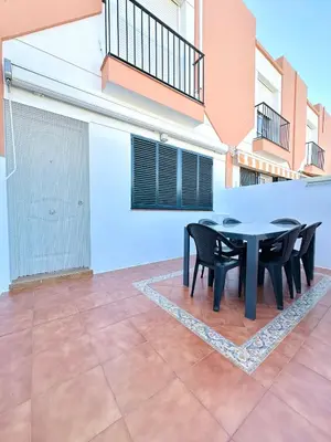 a patio with a black table and chairs on it at Casa 3 dormitorios La Barrosa in Chiclana de la Frontera