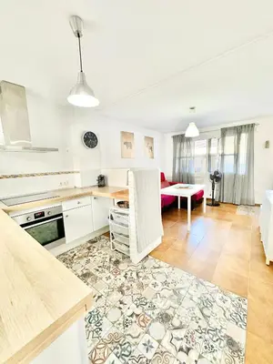 a kitchen and living room with a table and a couch at Casa 3 dormitorios La Barrosa in Chiclana de la Frontera