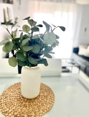 a white vase with a plant in it on a counter at Apartamento Atlántico in Rota