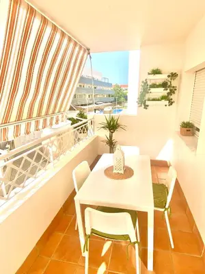 a balcony with a white table and chairs and a window at Apartamento Atlántico in Rota