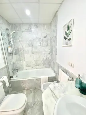 a bathroom with a toilet and a tub and a sink at Apartamento Atlántico in Rota