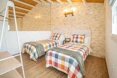 two beds in a room with brick walls at Casa Rural Mirador del Guadalquivir-Refugio con Piscina y Chimenea in Trebujena