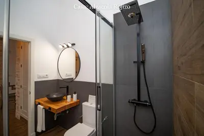 a bathroom with a shower with a toilet and a mirror at Casa Rural Mirador del Guadalquivir-Refugio con Piscina y Chimenea in Trebujena