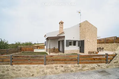 a house with a wooden fence in front of it at Casa Rural Mirador del Guadalquivir-Refugio con Piscina y Chimenea in Trebujena