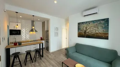 a living room with a couch and a kitchen at Sibs Sanlúcar Lucero Edificio Unico Terraza Tranquilo in Sanlúcar de Barrameda