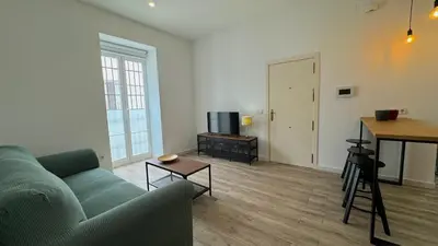 a living room with a couch and a television at Sibs Sanlúcar Lucero Edificio Unico Terraza Tranquilo in Sanlúcar de Barrameda