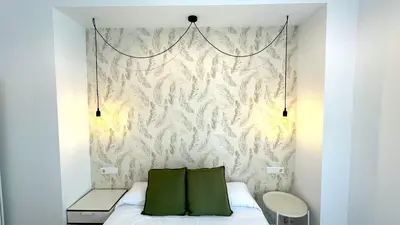 a bedroom with a bed with two green pillows at Sibs Sanlúcar Lucero Edificio Unico Terraza Tranquilo in Sanlúcar de Barrameda