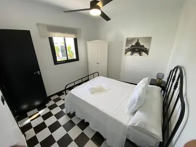 a bedroom with a bed and a checkered floor at Villa con piscina Camino Doñana in Sanlúcar de Barrameda