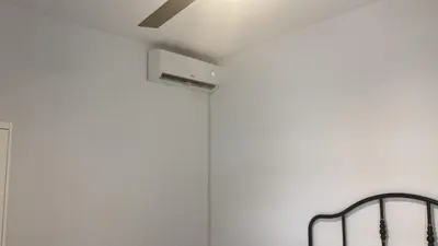 a ceiling fan in a room with a white wall at Villa con piscina Camino Doñana in Sanlúcar de Barrameda