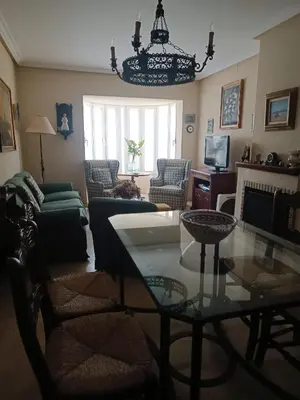 a living room with a table and a chandelier at Casa Mar Baltico a 200 m de la Playa La Barrosa in Chiclana de la Frontera
