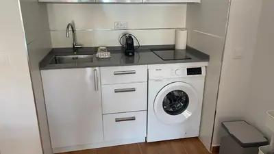 a small kitchen with a sink and a washing machine at Bahia Sur Deluxe in San Fernando