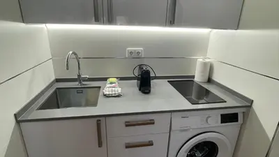 a kitchen with a sink and a washing machine at Bahia Sur Deluxe in San Fernando