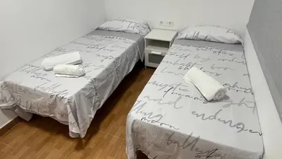 two beds in a room with writing on the sheets at Bahia Sur Deluxe in San Fernando