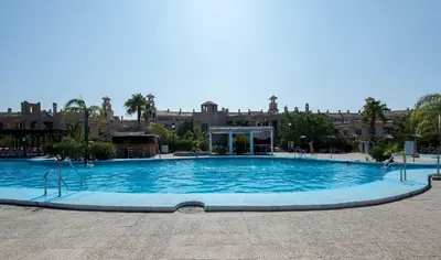 a large blue swimming pool with buildings in the background at Bahia Sur Deluxe in San Fernando